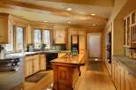 This stunning kitchen boasts a rustic-chic design with knotty pine cabinets, exposed wood beams, and a large island.