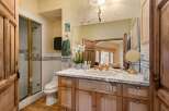 This charming bathroom boasts a rustic-chic design with wood cabinets, white tile, and decorative trim.