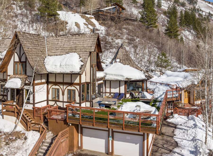 This stunning mountain home boasts a unique architectural design with a charming, fairytale-like aesthetic.