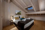 This stunning attic bedroom boasts a cozy and luxurious atmosphere, featuring a king-size bed with plush bedding and a faux fur throw.