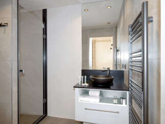 Modern bathroom with a sleek black sink and a frameless glass shower enclosure.