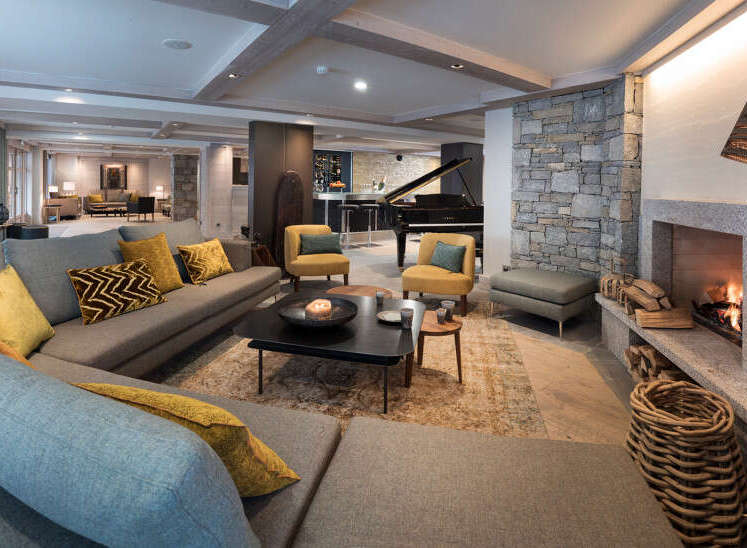 This luxurious living space boasts a spacious L-shaped sofa, perfect for relaxing by the cozy fireplace.
