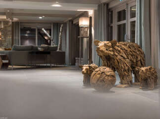 This stunning hotel lobby features unique driftwood sculptures of bears and cubs, adding a touch of rustic charm.