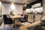This stunning apartment boasts a modern, fully equipped kitchen with sleek cabinetry and high-end appliances.