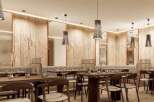 Experience fine dining in our elegant restaurant, featuring a warm and inviting atmosphere with natural wood accents and stylish pendant lighting.