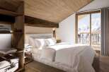 Cozy chalet bedroom with wooden accents and mountain views.