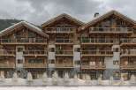 Luxury chalet-style apartments in a stunning snowy mountain setting.