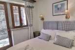 Charming bedroom with stone wall view and gingham details.