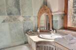 This stunning bathroom boasts a rustic-chic design with slate tile walls and a unique wooden vanity.