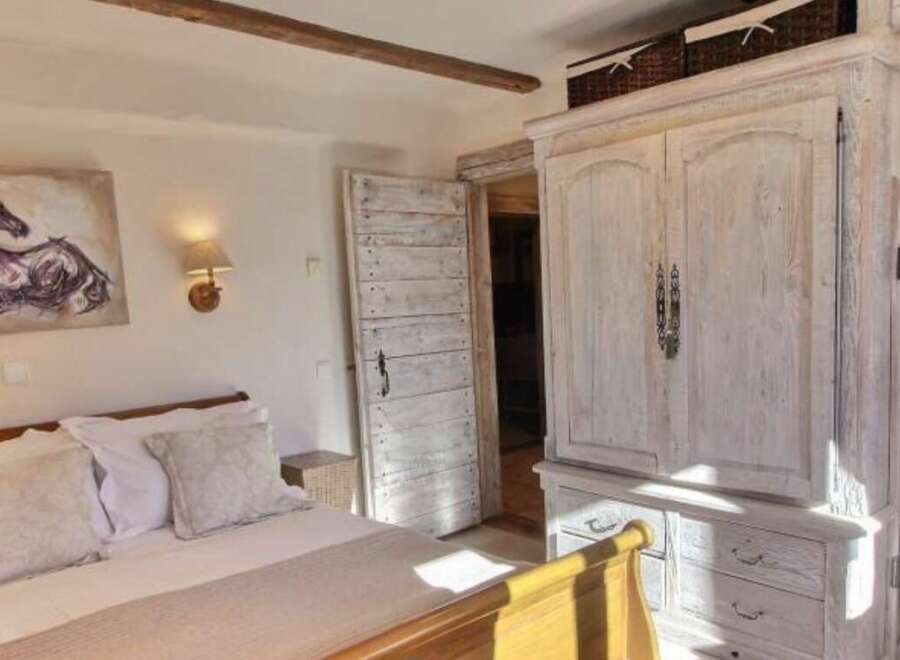 Charming bedroom with antique wooden wardrobe and ensuite bathroom.
