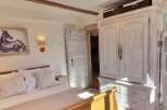 Charming bedroom with antique wooden wardrobe and ensuite bathroom.