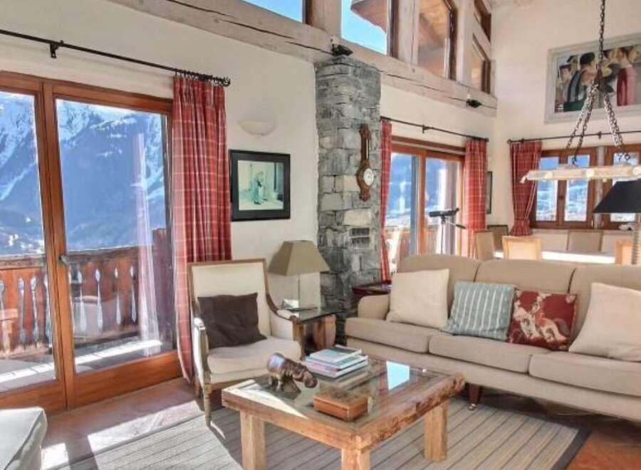 This stunning chalet boasts breathtaking mountain views, floor-to-ceiling windows, and a spacious living area perfect for relaxation.