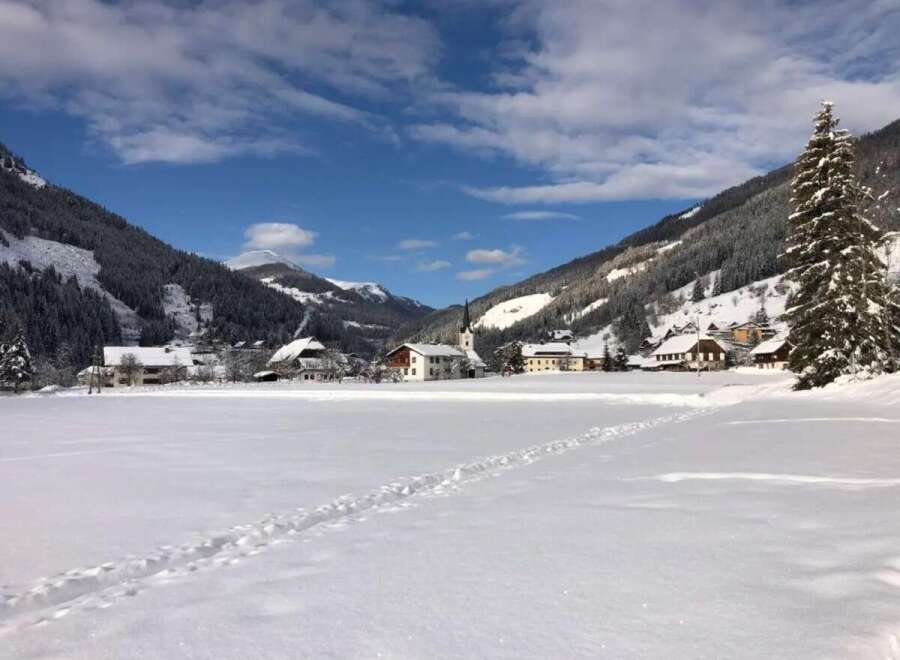 Nestled in a picturesque winter wonderland, this property offers stunning views of snow-capped mountains and a charming village.