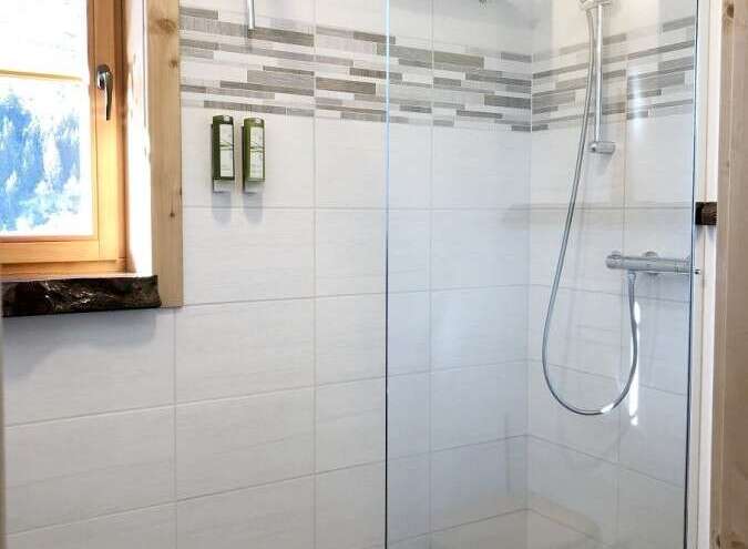 Step into a modern bathroom oasis with a sleek glass shower enclosure.
