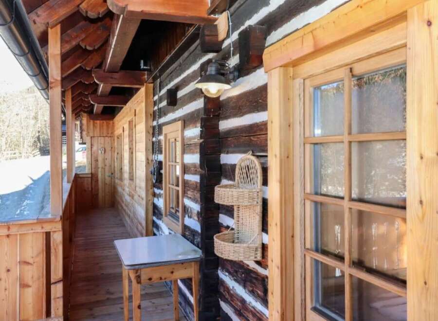 This charming wooden cabin boasts a rustic exterior with a welcoming porch.