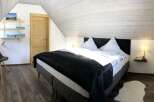 This cozy bedroom features a comfortable bed with a dark blanket, perfect for a relaxing stay.