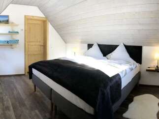 This cozy bedroom features a comfortable bed with a dark blanket, perfect for a relaxing stay.