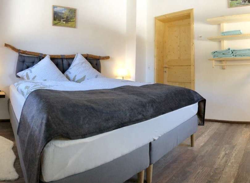 This cozy bedroom features a comfortable bed with a stylish headboard and soft bedding, perfect for a relaxing stay.
