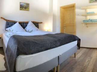 This cozy bedroom features a comfortable bed with a stylish headboard and soft bedding, perfect for a relaxing stay.