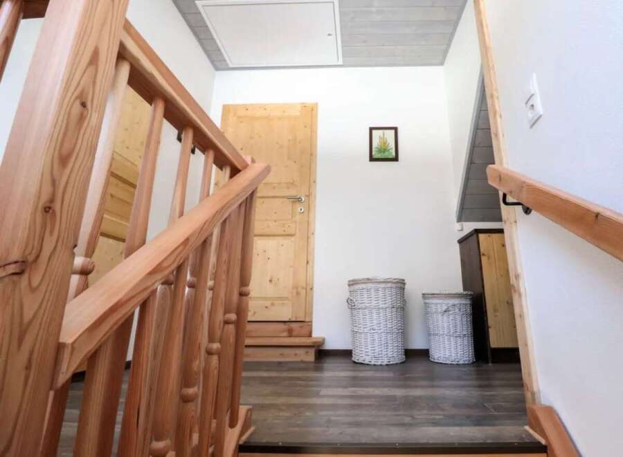 This inviting entryway showcases a beautifully crafted wooden staircase, leading to a bright and airy space.