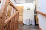 This inviting entryway showcases a beautifully crafted wooden staircase, leading to a bright and airy space.