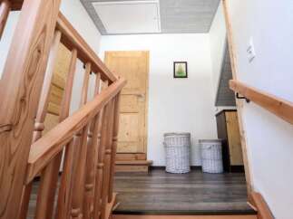 This inviting entryway showcases a beautifully crafted wooden staircase, leading to a bright and airy space.