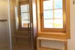 This bathroom features a modern glass shower enclosure, complemented by a wooden window frame that adds warmth and character.