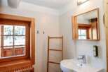 This charming bathroom features a rustic wooden window and mirror frame, adding warmth and character to the space.