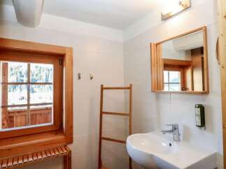 This charming bathroom features a rustic wooden window and mirror frame, adding warmth and character to the space.