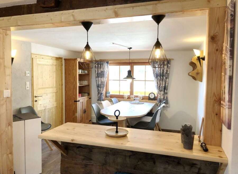 Discover this charming property featuring a cozy dining area with stylish pendant lights and a rustic wooden bar.