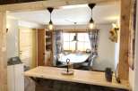 Discover this charming property featuring a cozy dining area with stylish pendant lights and a rustic wooden bar.