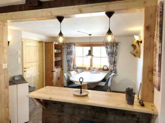 Discover this charming property featuring a cozy dining area with stylish pendant lights and a rustic wooden bar.