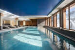 Indulge in a luxurious indoor pool experience, surrounded by floor-to-ceiling windows offering breathtaking mountain views.