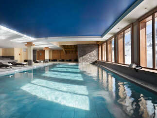 Indulge in a luxurious indoor pool experience, surrounded by floor-to-ceiling windows offering breathtaking mountain views.