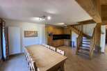 This stunning chalet boasts a spacious open-plan living area with a large wooden dining table perfect for family gatherings.