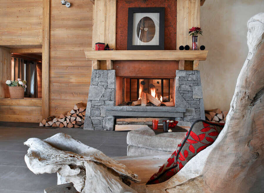 This stunning chalet boasts a rustic-chic living room with a large stone fireplace as the focal point.