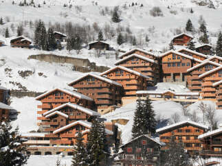 Discover the charm of these stunning wooden chalets nestled in a snowy mountain landscape.