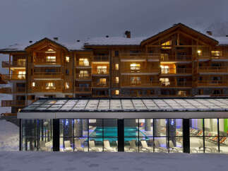 This stunning chalet-style hotel boasts a beautiful indoor pool and spacious rooms with balconies, perfect for a relaxing winter getaway.