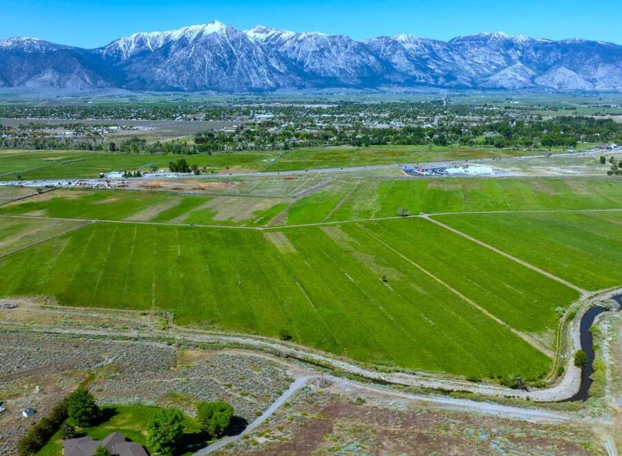 This expansive property boasts lush green fields, ideal for agriculture, with a tranquil waterway meandering through the landscape.