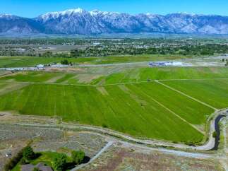 This expansive property boasts lush green fields, ideal for agriculture, with a tranquil waterway meandering through the landscape.