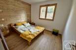 This charming bedroom features a cozy wooden bed frame and a warm, inviting atmosphere.