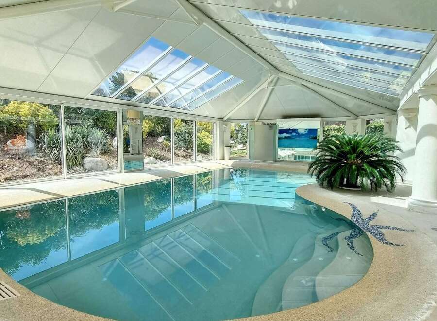 Indulge in luxury with this stunning indoor pool, boasting a glass ceiling that bathes the space in natural light.