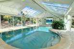 Indulge in luxury with this stunning indoor pool, boasting a glass ceiling that bathes the space in natural light.