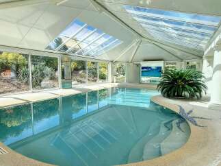 Indulge in luxury with this stunning indoor pool, boasting a glass ceiling that bathes the space in natural light.