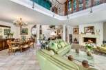 This stunning property boasts a grand, open-plan living area with high ceilings and a beautiful fireplace, creating a warm and inviting atmosphere.