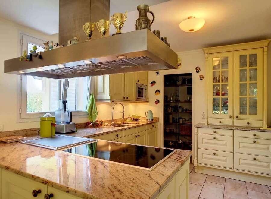 This stunning kitchen boasts granite countertops and custom cabinetry, creating a bright and airy atmosphere.