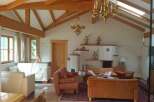 This stunning property boasts a warm and inviting living space with exposed wooden beams and a vaulted ceiling.