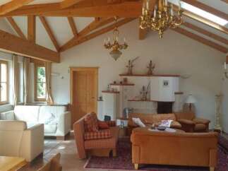 This stunning property boasts a warm and inviting living space with exposed wooden beams and a vaulted ceiling.