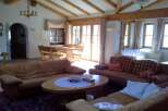 This cozy living room features a warm and inviting atmosphere with its wooden beams and comfortable seating.