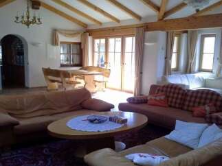This cozy living room features a warm and inviting atmosphere with its wooden beams and comfortable seating.